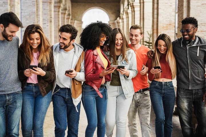 Young happy people together on cell phones