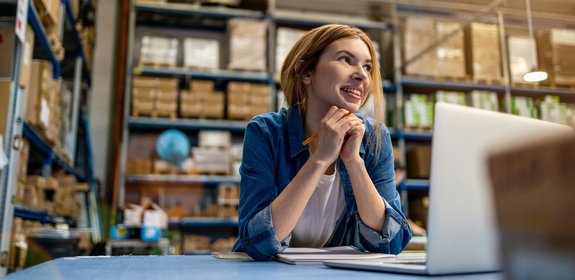 Woman works on her laptop in a sorting centre.