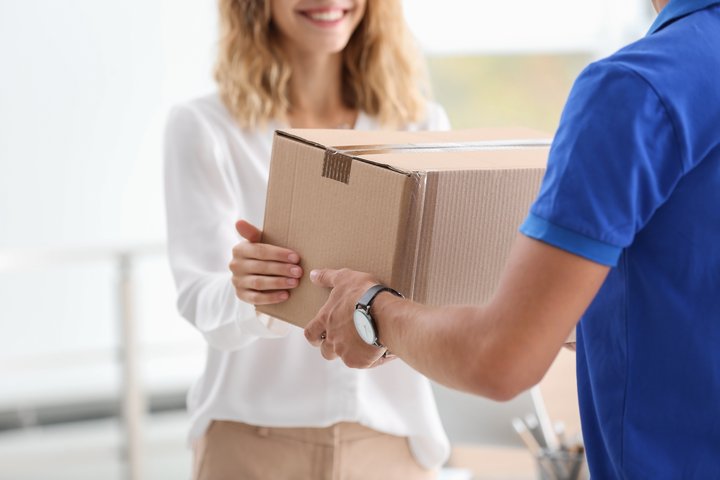 Woman receiving a parcel without signing any declaration document, as expected in the Spring GDS customs clearance solution.